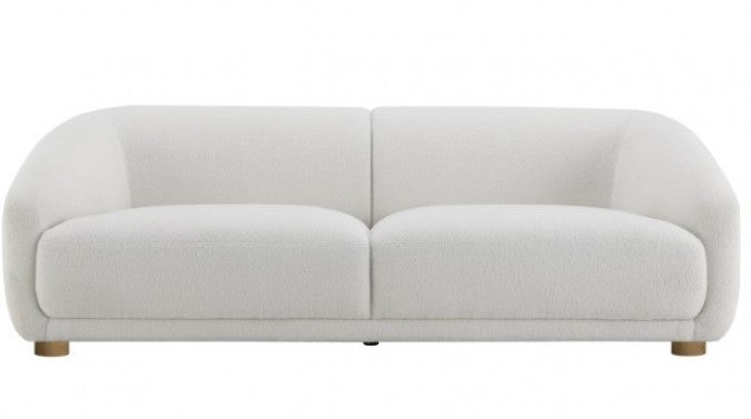 Aaron Contemporary White Boucle Loveseat Sloped Arms White sofa in a modern living room with a scenic view of mountains and water.