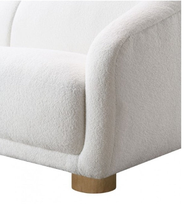 Aaron Contemporary White Boucle Loveseat Sloped Arms Close-up of a white upholstered chair with wooden leg on a white background