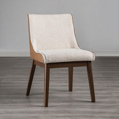 Abram Mid Century Modern Walnut Dining Chair A modern dining chair with a cream textured fabric upholstered seat and backrest, supported by a light wood frame and dark brown tapered legs, set against a neutral gray wall and wood-look floor.