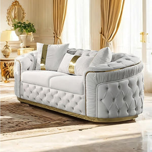 Adriana Glam Beige Loveseat Button Diamond Pleated Tufting Luxurious white sofa with gold accents in a stylish room.