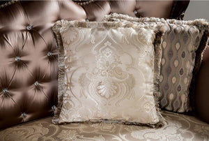 Decorative pillows with intricate patterns on a brown upholstered chair