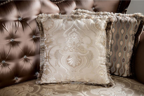 Decorative pillows with intricate patterns on a brown upholstered chair