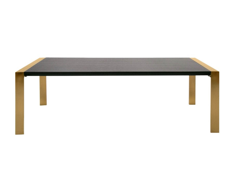 Alessa Modern Dining Table - Brass & Wenge Modern dining room with a glass table, black chairs, and a decorative wall piece.