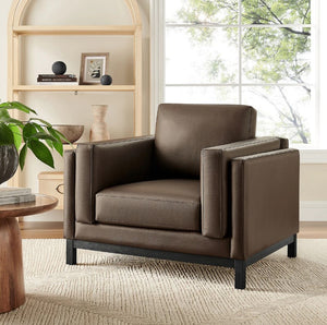 Amadeo Espresso Vegan Leather Modern Chair Brown leather armchair in a living room setting with a window and bookshelf in the background.