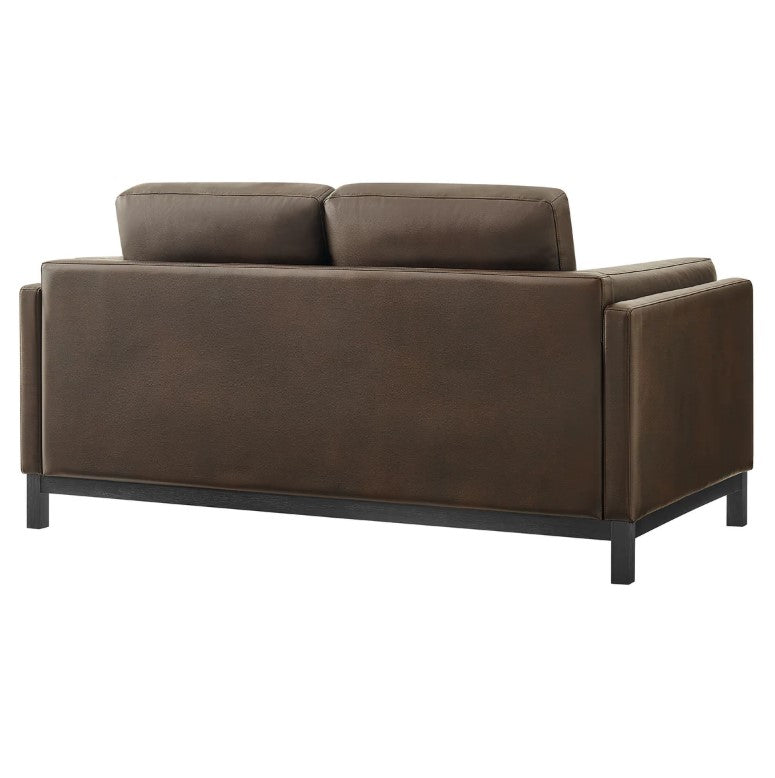 Amadeo Espresso Vegan Leather Modern Loveseat Brown leather sofa in a living room with a plant and window in the background