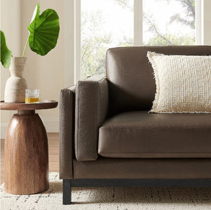 Amadeo Espresso Vegan Leather Modern Sofa Brown sofa with a textured pillow in a living room setting.