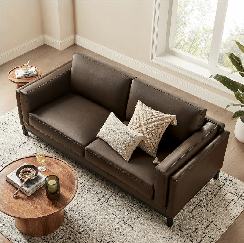 Amadeo Espresso Vegan Leather Modern Sofa Brown leather sofa in a living room with a lamp and window in the background