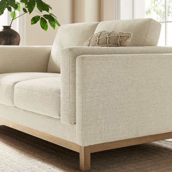 Amadeo Ivory Deep Seat Comfort Modern Fabric Loveseat Beige sofa with wooden legs in a living room setting