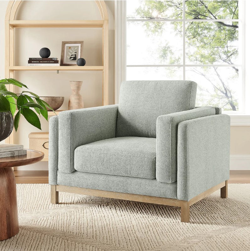 Amadeo Mist Deep Seat Comfort Modern Fabric Chair Gray armchair in a living room with a bookshelf and window in the background