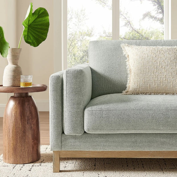 Amadeo Mist Deep Seat Comfort Modern Fabric Sofa Light gray sofa with wooden side table and plant in a living room setting
