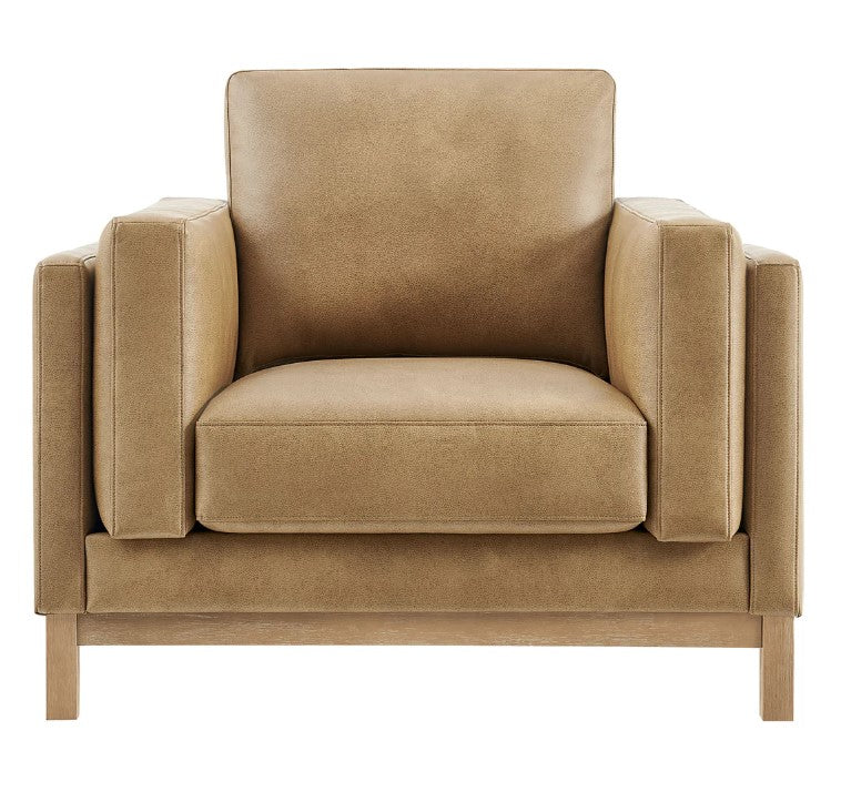 Amadeo Toast Vegan Leather Modern Chair Beige armchair in a living room setting with a bookshelf and window in the background.