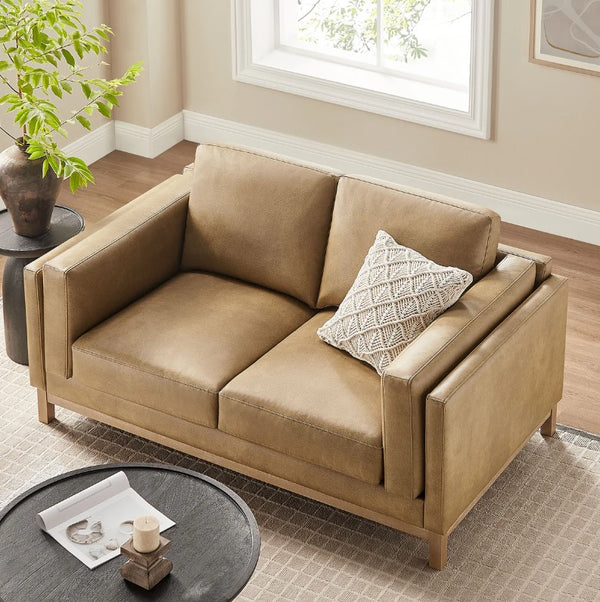 Amadeo Toast Vegan Leather Modern Loveseat Beige sofa with a decorative pillow in a living room setting