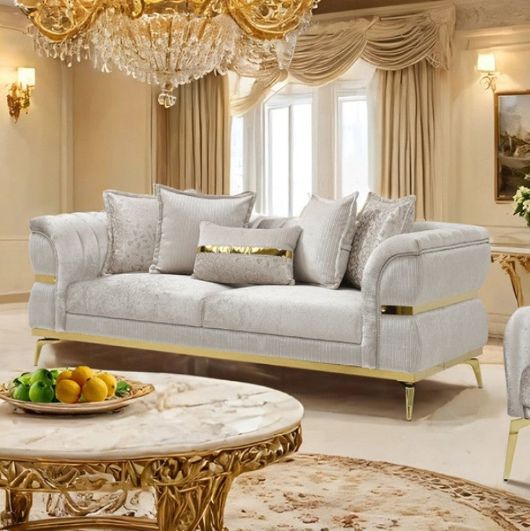 Ari Glam Beige Sofa Flare Channeled Arms Gold Accents Luxurious living room with a gray sofa, gold coffee table, and chandelier.