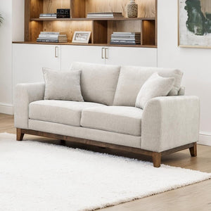 Light gray sofa in a living room with wooden shelves and decor.