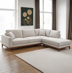 Arieal Mid-Century Modern Chenille Fabric Sectional Light gray sectional sofa in a living room with large windows and a rug.