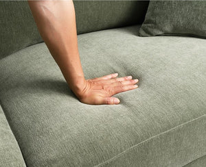 Arieal Mid-Century Modern Olive Green Chenille Fabric Sectional Hand resting on a textured green sofa