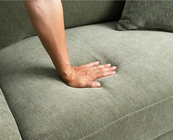 Arieal Mid-Century Modern Olive Green Chenille Fabric Sectional Hand resting on a textured green sofa