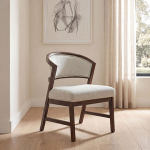 Artemos Contemporary Dark Brown Upholstered Chair A wooden dining chair with a curved backrest and light beige upholstered seat and back, shown in a bright room with wood floors, sheer curtains, and framed wall art.