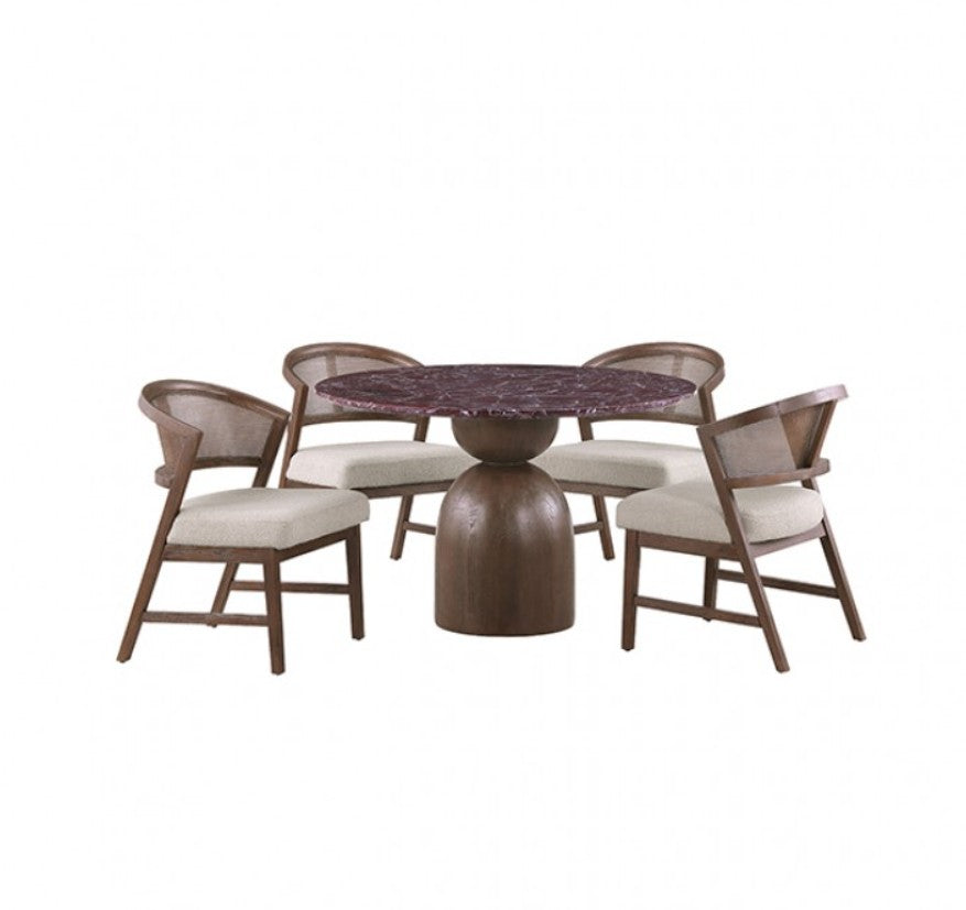 Artemos Contemporary Red Round Dining Table A round dining table with a dark reddish-brown marble top and a substantial dark wood pedestal base, surrounded by two woven-back chairs with cream upholstered seats in a softly lit room.