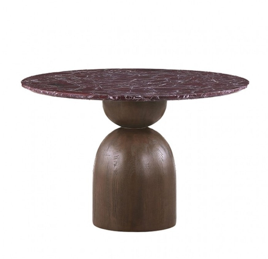 Artemos Contemporary Red Round Dining Table A round dining table with a dark reddish-brown marble top and a substantial dark wood pedestal base, surrounded by two woven-back chairs with cream upholstered seats in a softly lit room.