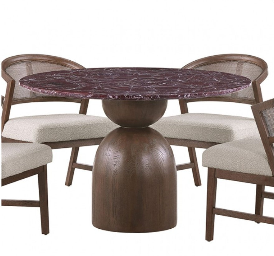 Artemos Contemporary Red Round Dining Table A round dining table with a dark reddish-brown marble top and a substantial dark wood pedestal base, surrounded by two woven-back chairs with cream upholstered seats in a softly lit room.