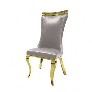 Asher Gold Gray Leatherette Dining Chair 2-Pack A luxury dining chair featuring a tall, high-back curved backrest upholstered in textured light gray fabric, accented with shiny gold metal trim at the top of the backrest and on the curved legs.