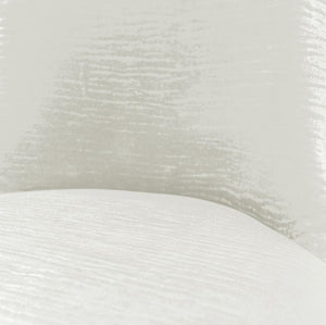 Asher Silver White Leatherette Dining Chair A close-up of a white textured fabric or material surface with a soft curved edge and subtle sheen.