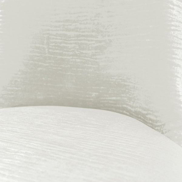 Asher Silver White Leatherette Dining Chair A close-up of a white textured fabric or material surface with a soft curved edge and subtle sheen.