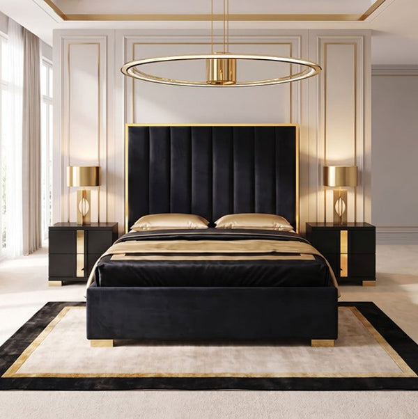 Ashysko Black Gold Fully Upholstered Bed A luxury black velvet bed frame with a tall channel-tufted headboard and matching footboard, styled in a modern bedroom with gold accents, including a gold ring pendant light, gold bedside tables, and a patterned rug.