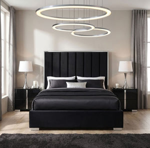 Ashysko Black Silver Fully Upholstered Bed A modern bedroom featuring a black upholstered bed with a tall segmented headboard, black nightstands, silver lamps, and a large circular ring chandelier hanging above the bed.