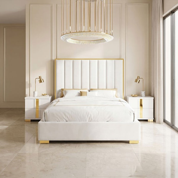 Ashysko White Gold Fully Upholstered Bed A luxury modern bedroom featuring a white upholstered bed with gold trim, matching white nightstands, a large circular crystal chandelier, and beige walls and marble floors.