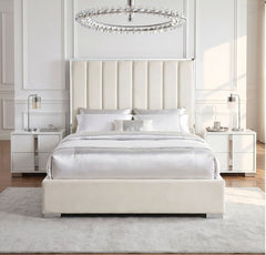 Ashysko White Silver Fully Upholstered Bed A modern cream upholstered bed with a tall channel-tufted headboard and matching footboard, styled in a bright, symmetrical bedroom with white nightstands, lamps, a light gray rug, and a crystal chandelier.