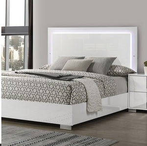 Asiko Modern Led Headboard White Bed A modern white bed frame with a tall rectangular backboard featuring integrated LED backlighting, styled with gray and white geometric patterned bedding in a contemporary bedroom setting.