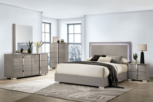 Asiko Modern UV Finish Light Taupe Chest A modern bedroom furniture set in a bright room, featuring a gray upholstered bed with a backlit headboard, a matching gray dresser with a mirror, a tall side cabinet, and a nightstand with a lamp.