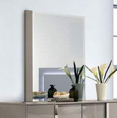 Asiko Modern UV Finish Light Taupe Mirror A modern wall-mounted rectangular mirror with a slim taupe frame, shown above a matching metallic console table. The scene is styled with decorative vases, a bowl of fruit, and a white vase of calla lilies against a clean white wall.