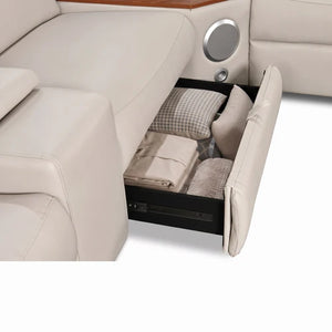 Aurelia Beige Modern Air Leather Sectional Sofa Powered Recliner A close-up of a beige leather reclining sofa with a storage compartment pulled open, showing folded bedding and pillows inside.