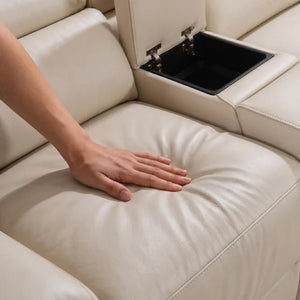 Aurelia Beige Modern Air Leather Sectional Sofa Powered Recliner Close-up of a cream leather sectional sofa seat with a hand resting on the cushion and an open center armrest storage compartment visible.
