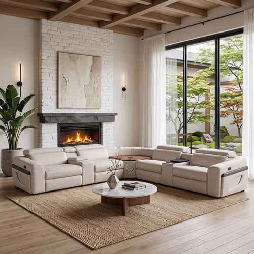 Aurelia Beige Modern Air Leather Sectional Sofa Powered Recliner A modern sectional sofa in light beige leather arranged in an open U-shape in a bright, contemporary living room with a white brick fireplace, large windows, and a wooden coffee table on a woven rug.