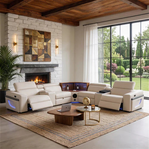 Aurelia Beige Modern Air Leather Sectional Sofa Powered Recliner A large cream leather reclining sectional sofa arranged in an open U-shape in a modern living room with a fireplace, wood ceiling beams, large windows, and a woven area rug.