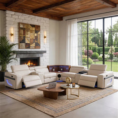 Aurelia Beige Modern Air Leather Sectional Sofa Powered Recliner A large cream leather reclining sectional sofa arranged in an open U-shape in a modern living room with a fireplace, wood ceiling beams, large windows, and a woven area rug.