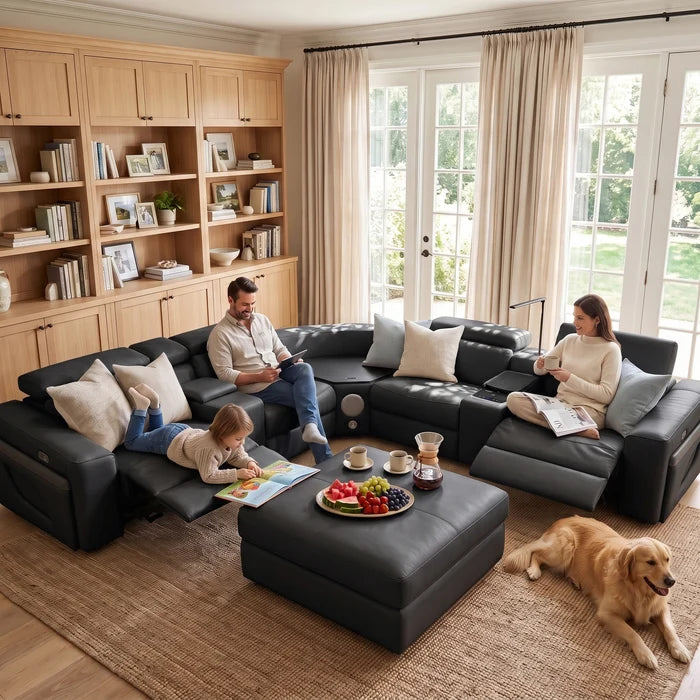 Aurelia Modern Air Leather Sectional Sofa Powered Recliner A large black leather reclining sectional sofa with built-in media console and side lighting, staged in a modern living room with a fireplace, stone wall, large windows, and outdoor greenery visible.