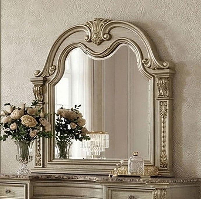 Aurora Decorative mirror with intricate gold frame on a wall above a dresser.