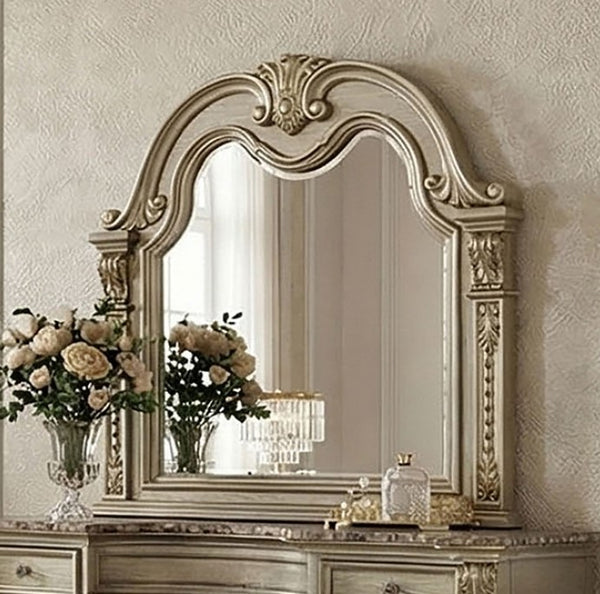 Aurora Decorative mirror with intricate gold frame on a wall above a dresser.