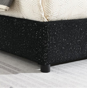Bassetti Modern Style Shelter Padded Black Bed Style Black textured bed frame with a geometric-patterned bedspread on a light gray carpet.