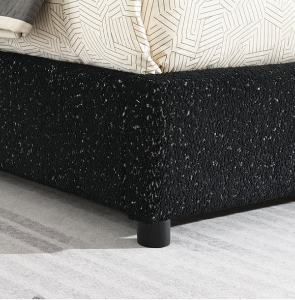Bassetti Modern Style Shelter Padded Black Bed Style Black textured bed frame with a geometric-patterned bedspread on a light gray carpet.