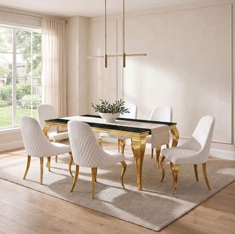 Betsy Black Glass Top Modern Dining Table A modern dining room set featuring a rectangular black table with gold legs and six matching black velvet chairs with gold legs, arranged on a light beige rug in a bright room with a window and pendant light.