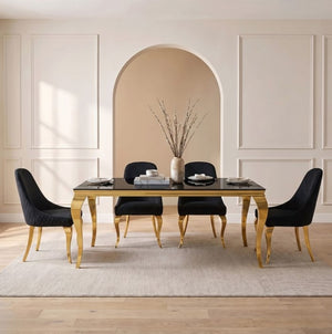 Betsy Black Glass Top Modern Dining Table A modern dining room set featuring a rectangular table with a black glass top and gold legs, surrounded by four black upholstered chairs with gold legs, set on a light beige rug in a neutral room.