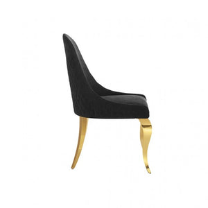 Betsy Black Upholstered Modern Chair (2/CTN) A modern dining chair with a black textured velvet upholstered seat and high curved backrest, supported by elegant curved gold metal legs, shown from a side profile on a white background.