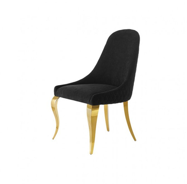 Betsy Black Upholstered Modern Chair (2/CTN) A modern dining chair with a black quilted velvet upholstered seat and curved backrest, supported by elegant curved gold-finished legs, shown against a plain white background.