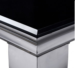 Betsy Silver Black Glass Top Modern Dining Room Table Close-up of a polished chrome pedestal table corner with a glossy black top surface.